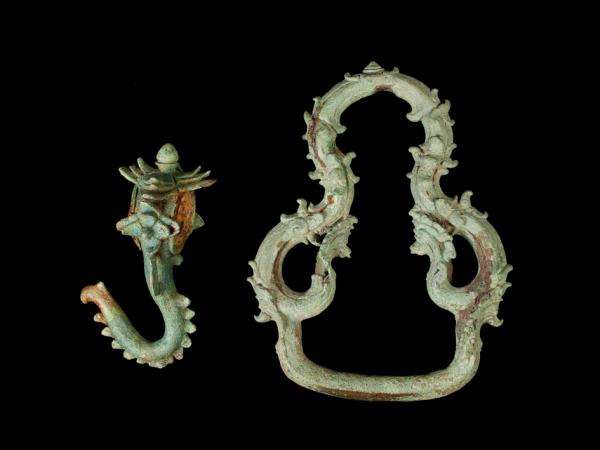 Image of two jewelry items, a hook and a ring against a black backdrop